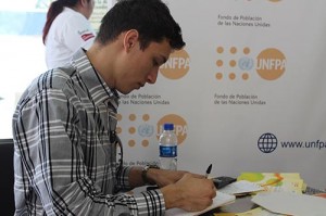 Un joven escribe su petición para ser presentada a la ONU por medio del Unfpa El Salvador.