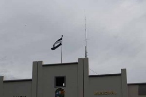 Esta bandera nacional ondea en un edificio municipal y podría significar el destoso al que la someten las actitudes antipatrióticas.