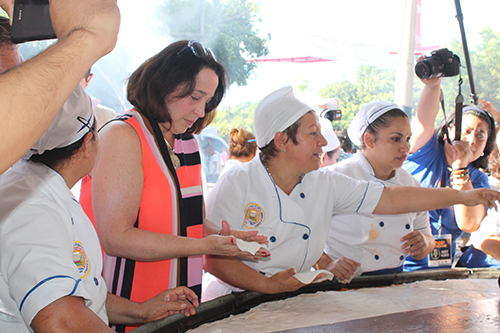Jean Manes ayuda a elaborar la pupusa gigante.